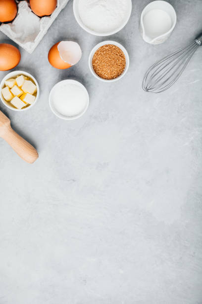 istock Baking ingredients. Flour, eggs, sugar, butter, roller pin and whisk on the kitchen table. 1367114040