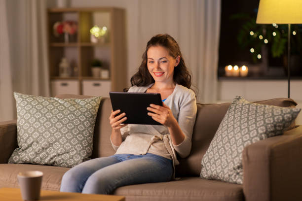 istock happy woman with tablet pc at home in evening 1367114714