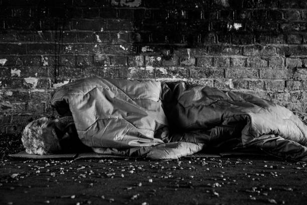 istock Senior homeless man sleeping rough in dark tunnel 1367116350
