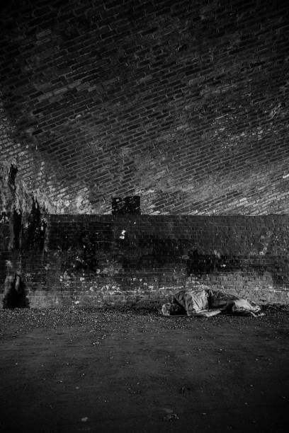 istock Senior homeless man sleeping rough in dark tunnel 1367116382