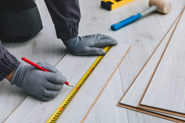 istock Worker installing new laminated wooden floor 1367116389
