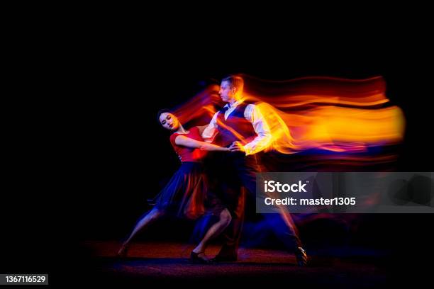 Dynamic Portrait Of Young Ballroom Dancers Dancing Argentine Tango Isolated On Dark Background With Neon Mixed Light Stock Photo - Download Image Now