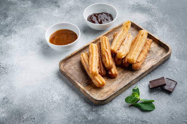 istock Churros with sugar and chocolate sauce, on gray background with space for text, copyspace 1367116869
