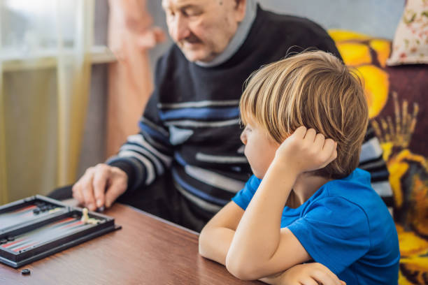 istock Senior man and his grandson play backgammon 1367117559