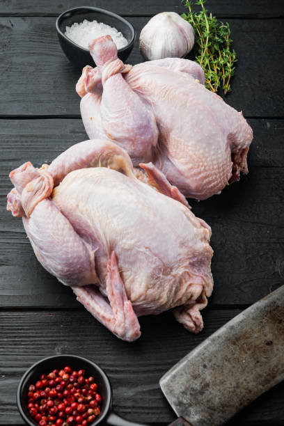 istock Fresh raw chicken with herbs spices ingredients, on black wooden table 1367118401
