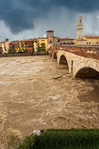 Verona, Ponte Pietra (Stone bridge), I century B.C, and Adige river in flood after several violent storms. UNESCO world heritage site, Veneto, Italy, Europe.