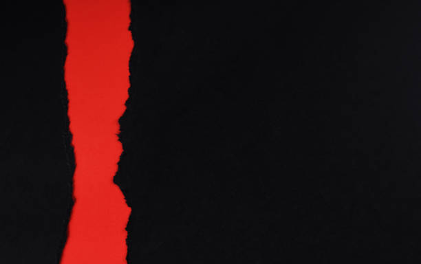 istock Black paper with torn edges isolated with red colored paper background inside. Good paper texture 1367124393