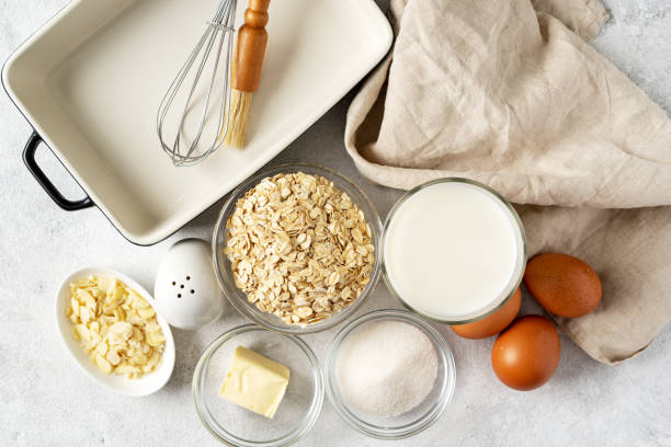istock Ingredients for pudding or oatmeal pie on a light gray culinary background. Eggs, cereals, almonds, sugar, milk and butter on the kitchen table. Top view 1367124439