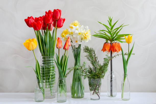 istock Different spring flowers in transparent vases on the table. 1367124711