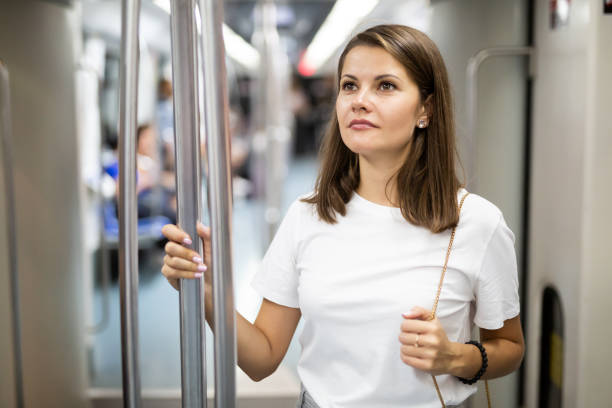 istock Female passenger standing in subway car 1367126001