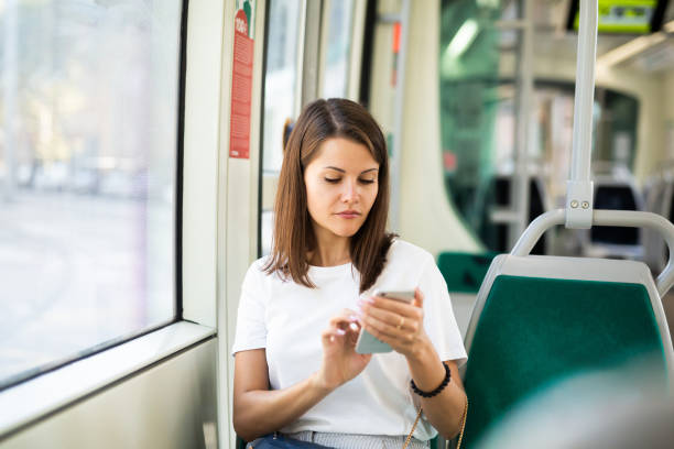 istock Woman using phone in modern tram 1367126008