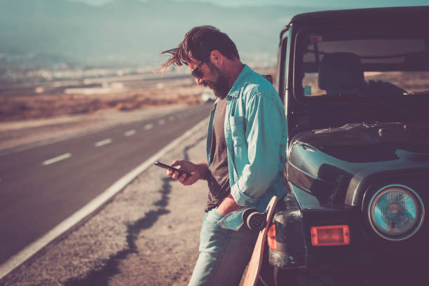 istock Side View Of Man Using Mobile Phone By Car 1367130236