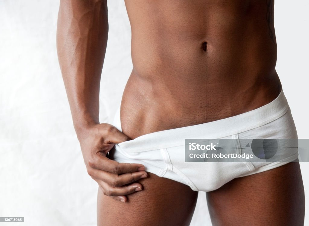 Tight Waistline with Briefs A very fit young black man pulls his briefs to show his flat, muscular stomach. Men Stock Photo