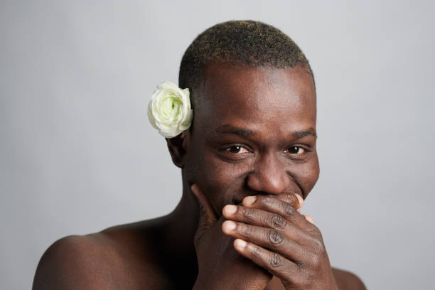 istock Young African man covering his mouth while laughing 1367132463