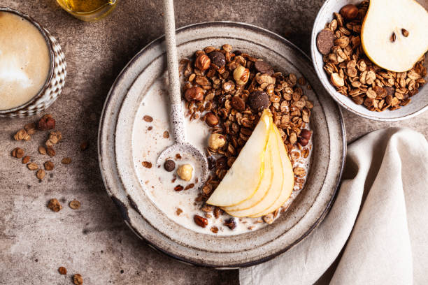 muesli al cioccolato con latte di mandorla, pera e miele. - almond bowl ceramic food foto e immagini stock