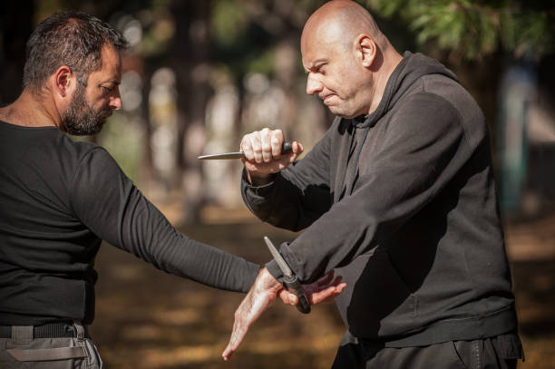 istock Knife vs knife fight. Kapap instructors demonstrates sombrada drill training 1367133940