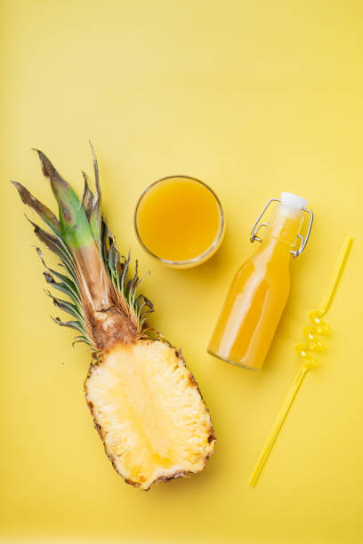 istock Pineapple juice, on yellow textured summer background, top view flat lay 1367135884