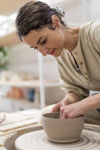 istock Female ceramic artist in apron working in pottery workshop 1367137192