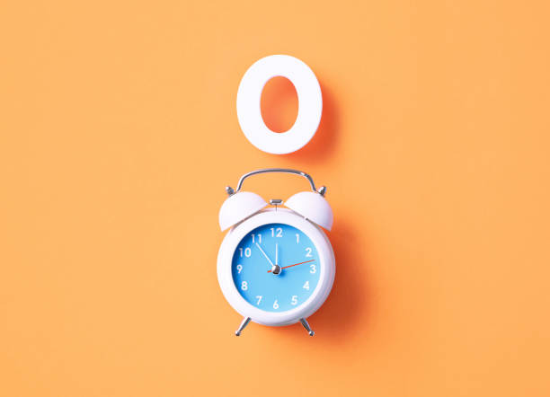 istock Number 0 Sitting Above White Alarm Clock On Orange Background 1367138385
