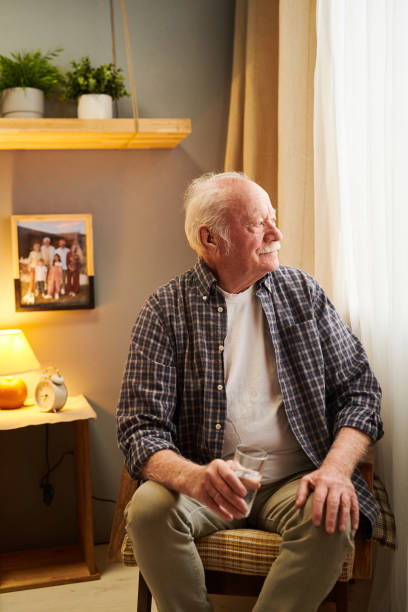 istock Aged restful man in casualwear sitting by window 1367139955