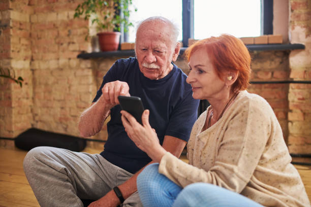 istock Elderly man pointing at smartphone screen during discussion with mature female 1367140023