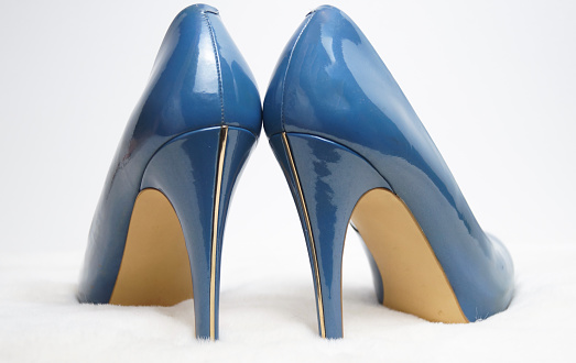 Blue high-heeled shoes on a white fur rug. High quality photo