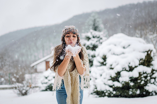 Young caucasian woman enjoying the snowy winter day