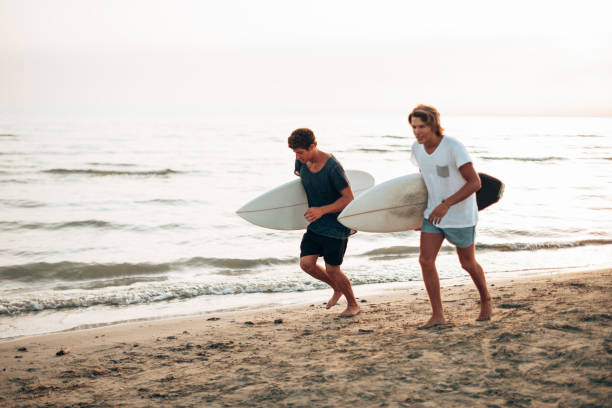 istock young people run on the beach with surfboard 1367141184