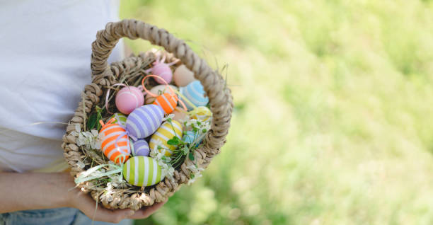 búsqueda de huevos de pascua en el jardín de primavera. divertida adolescente con canasta de huevos y orejas de conejo en la búsqueda de huevos de pascua en el soleado jardín de primavera. - bunny girl fotografías e imágenes de stock