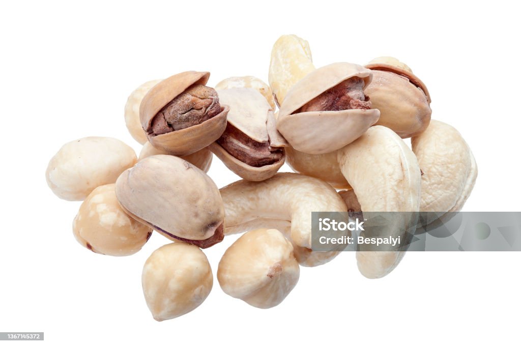 peeled hazelnuts and cashew with salted pistachio in shell, pile 
 of deferent nuts close-up of protein healthy food isolated on white background, nobody. Cashew Stock Photo