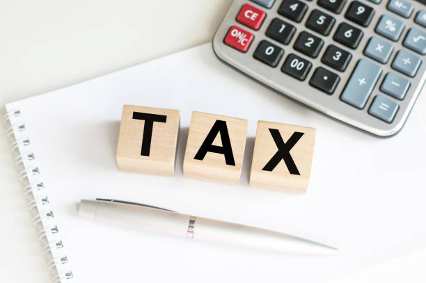 istock TAX on wooden cubes, notebook, calculator and a pen on a table. 1367145496