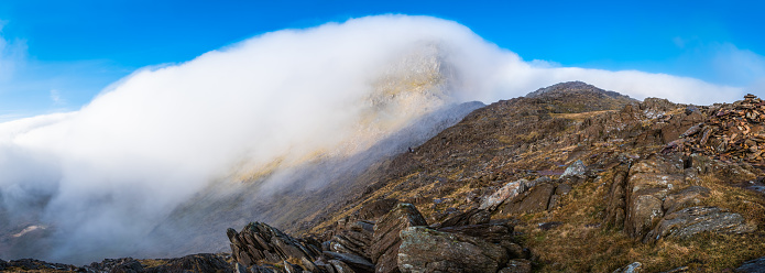 Clouds swirling over the summit ridge of Yr Wyddfa, Snowdon, along the Watkins Path in the heart of the Snowdonia National Park, Wales.