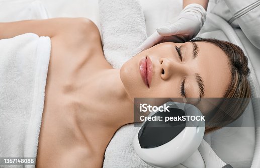istock Woman receiving IPL procedure for her face at a beauty center to remove brown spots and treat rosacea. Facial Rejuvenation with intense pulsed light apparatus 1367148088