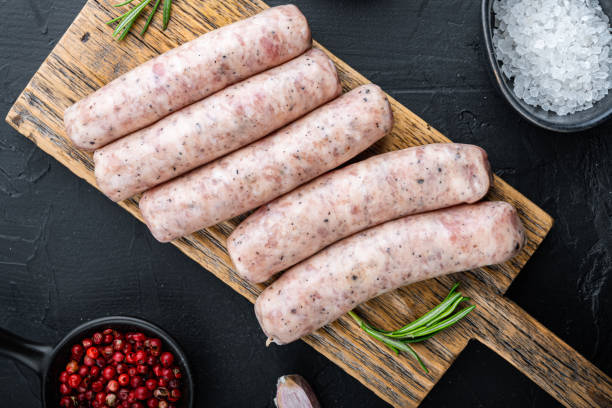 istock Homemade chicken sausages, top view, on black background 1367148385