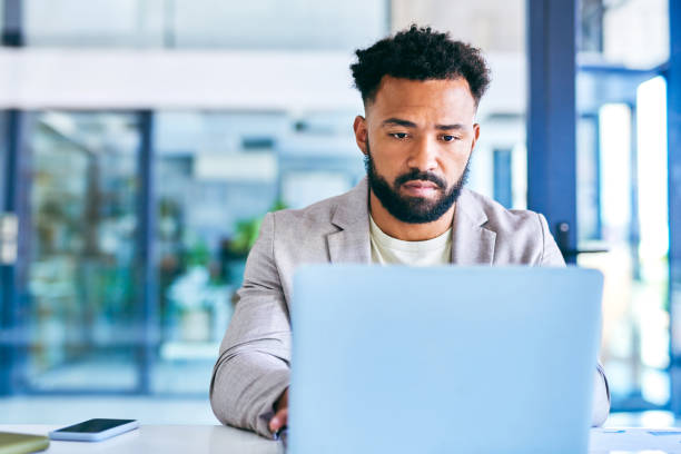 istock Shot of a young businessman using a laptop in a modern office at work 1367150117