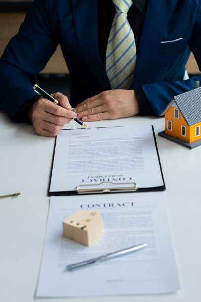 los agentes de ventas de viviendas ofrecen contratos de compra de viviendas y seguros a clientes en oficinas de bienes raíces. - real estate mortgage document key contract fotografías e imágenes de stock