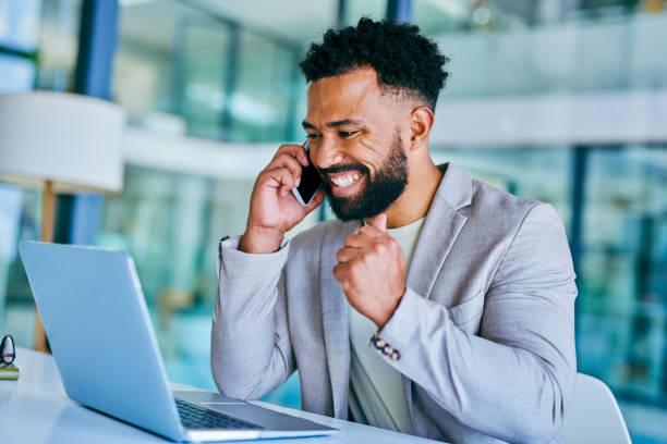 istock Shot of a young businessman using a laptop while on a call at work 1367150155