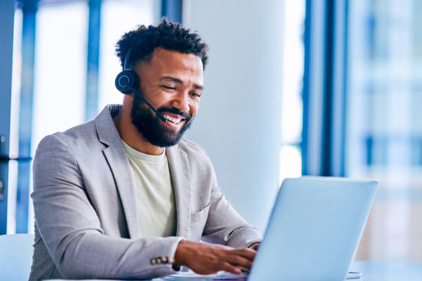istock Shot of a young male call center agent using a laptop while working in an office 1367150190