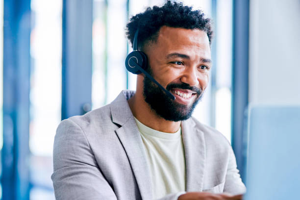 istock Shot of a young male call center agent using a laptop while working in an office 1367150229