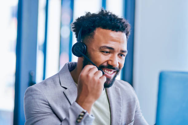 istock Shot of a young male call center agent using a laptop while working in an office 1367150237