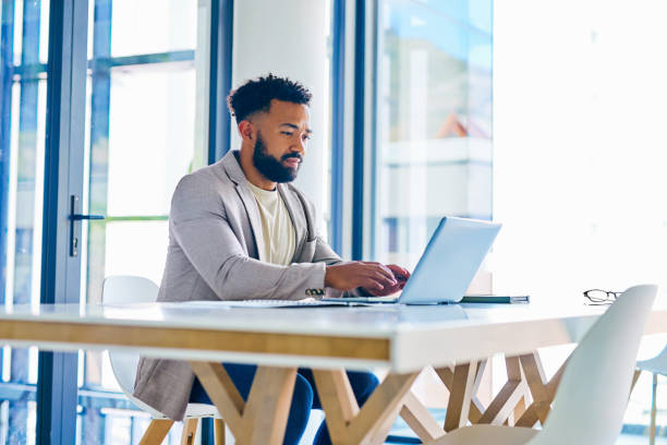 istock Shot of a young businessman using a laptop in a modern office at work 1367150238