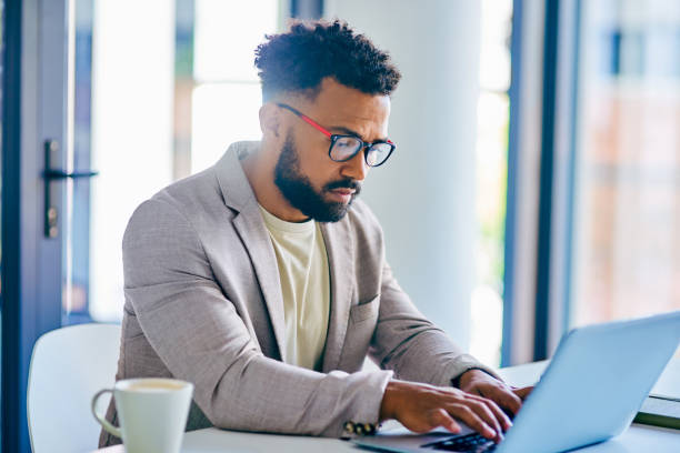 istock Shot of a young businessman using a laptop in a modern office at work 1367150246