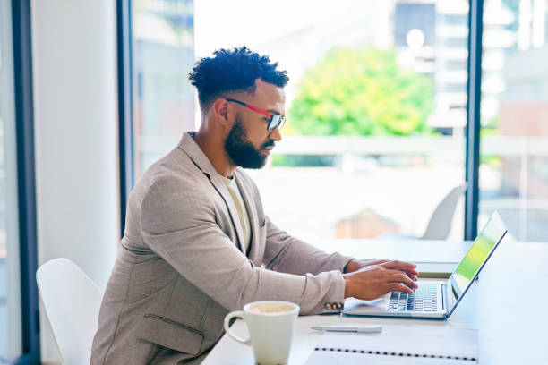 istock Shot of a young businessman using a laptop in a modern office at work 1367150253