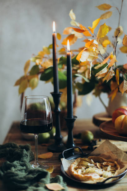 acogedora imagen con velas encendidas y una copa de vino - autumn table setting flower fotografías e imágenes de stock