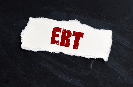 EBT word written on small paper. Abbreviation Earnings Before Taxes.