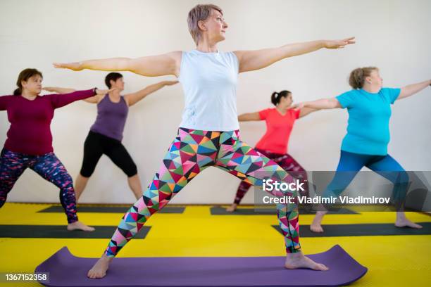 During A Yoga Class Ladies Are Performing The Warrior Pose Stock Photo - Download Image Now