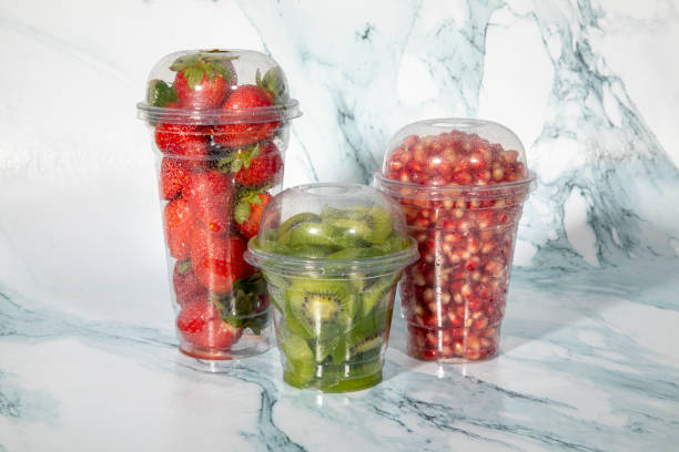 ensalada de frutas en vasos de plástico para llevar. bayas y frutas orgánicas en rodajas, bocadillos saludables - fruit cup fotografías e imágenes de stock