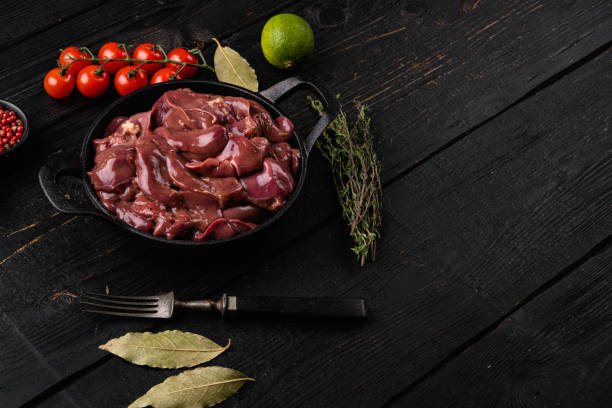 istock Fresh  chicken liver and ingredients, on black wooden table background, with copy space for text 1367153386