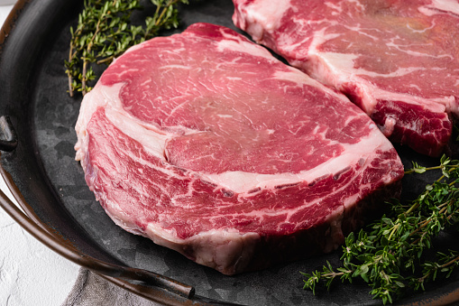 Classic fresh rib eye steak set, on white stone table background