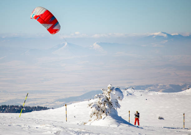 An athlete engages in winter kitesurfing under a colorful dome on snow-covered Lake Onega in the city of Petrozavodsk, Karelia on February 10, 2024.